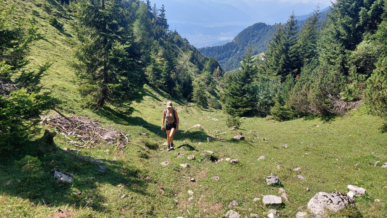 Nina wandert auf einem Bergpfad über den Tälern Tirols